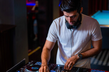 A professional DJ mixes a live set on a controller in a dark nightclub or bar A concept for electronic music entertainment and nightlife culture
