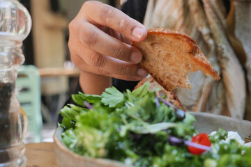 Enjoying fresh salad with bread during lunch at a cafe
