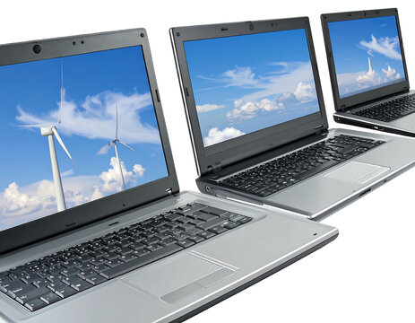 Three laptops display varying skyscapes, lined up and angled to the right with silver keyboards and black frames
