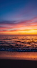Obraz premium Peaceful ocean horizon at sunset, featuring gentle waves rolling onto the sandy shore under a colorful twilight sky, sunset ,waves ,sunlight