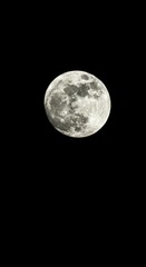 Fototapeta premium A brightly lit, detailed full moon dominates a vast, absolute black night sky. Perfect for astronomical themes and mystery and science ,full moon ,science ,dark