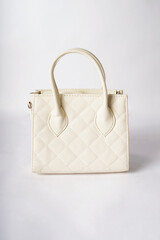 A cream-colored women's bag is placed against a white background