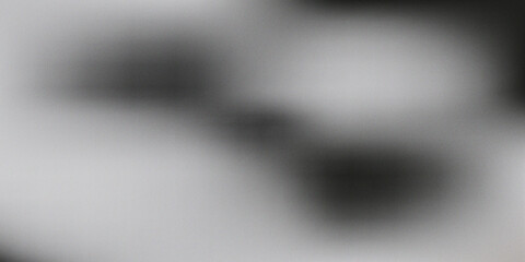 Abstract blurred grayscale image with dark and light contrasting shapes and grainy texture