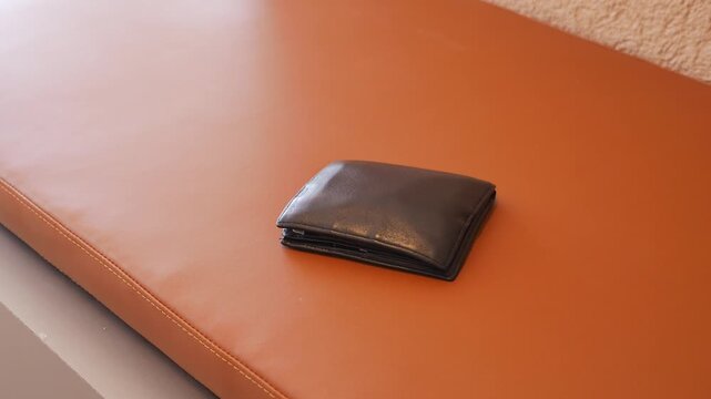 Wallet resting on a brown leather bench, lost wallet concept 