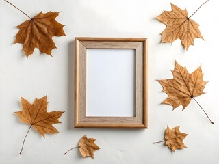 Flat lay composition with an empty wooden photo frame mockup surrounded by dry autumn maple leaves on a clean white background, top view