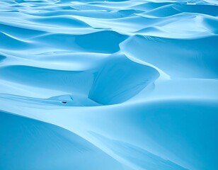 Abstract ocean-like patterns of smooth, icy-blue sand dunes