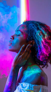 Retrato art&iacute;stico de mujer con rostro cubierto de pigmentos de colores vibrantes bajo luz ne&oacute;n intensa
