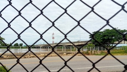 Chain link fence and the bridge across the river