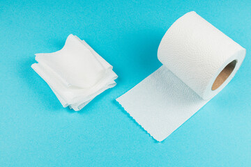 White paper towels and roll on blue background for cleaning tasks