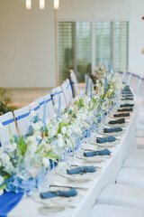Elegant table setting for festive dining with wine glasses, plates, flowers, candles