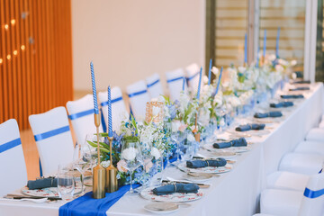 Elegant table setting for festive dining with wine glasses, plates, flowers, candles
