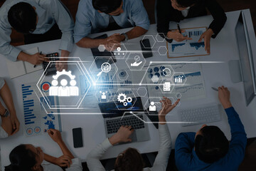 Team of professionals collaborating in a modern workspace analyzing data and utilizing technology for effective project management and strategic planning. Trope