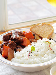 Red wine braised beef ribs with rice in white plate  