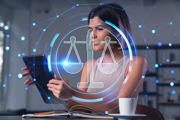 Smiling businesswoman in casual wear holding tablet device touching it at office workplace. Concept of distant work, business education, information technology. Law and order icons hologram