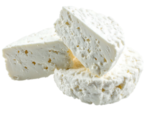 Stack of three irregularly shaped blocks of crumbly white cheese on a dark background