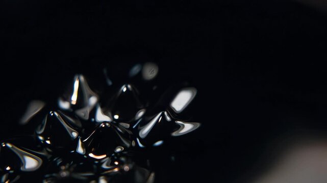 Close up of ferrofluid liquid metal spikes in a dark field