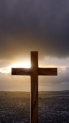 Christian cross with landscape view and dark dramatic sky background. Concept of Christianity, religious, faith, Jesus, or belief