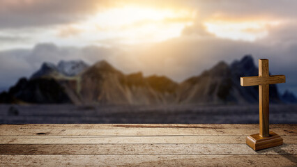 Christian cross on a wooden table with a landscape view and a dark dramatic sky background. Concept...