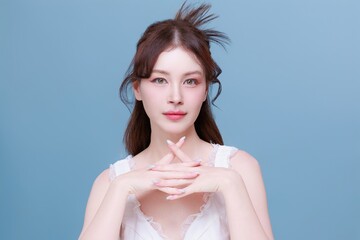 Asian woman model with natural makeup on face clean fresh skin on isolated blue background.