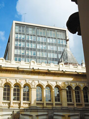 Fototapeta premium Part of an old building in the background with a tall, modern tower in downtown Bogotá, Colombia. Concept of architecture and tourism