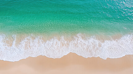 Turquoise ocean waves gently lap against sandy beach, creating serene coastal scene