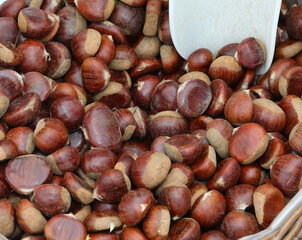crates of fruit for sale at the greengrocers market stall featuring brown chestnuts
