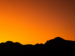 八ヶ岳の赤岳を染めるオレンジ色の夕暮れ空と雄大な山々の風景
