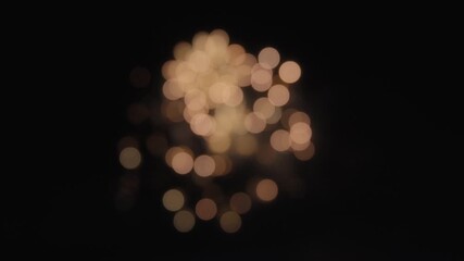 Abstract bokeh background of exploding orange fireworks on a dark night sky