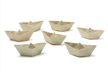 set of miniature folded paper boats on white background