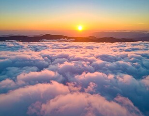 Aerial sunrise view, sun rising above rolling cloud sea, distant mountains