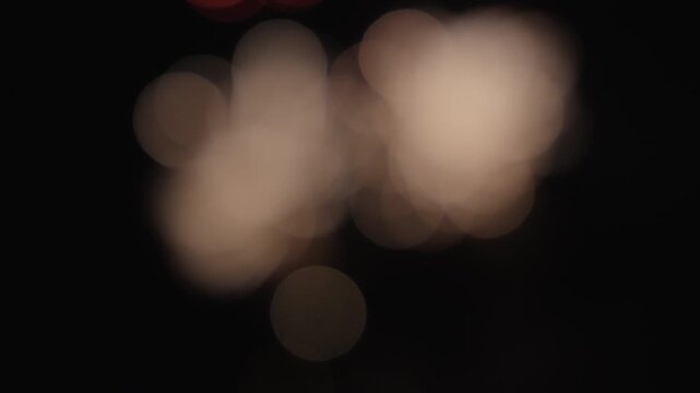 Real fireworks in a blurred bokeh abstract light up the night sky