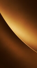 Abstract close-up of a curved golden-brown surface with a smooth gradient of light and shadow.