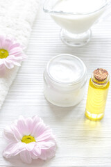flowers in bowl and oil on wooden background
