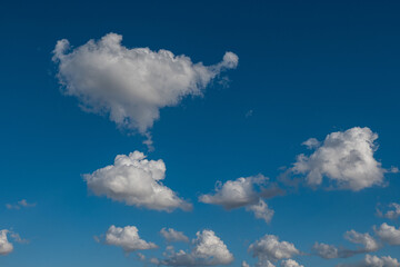 white cumulus clouds in blue sky.