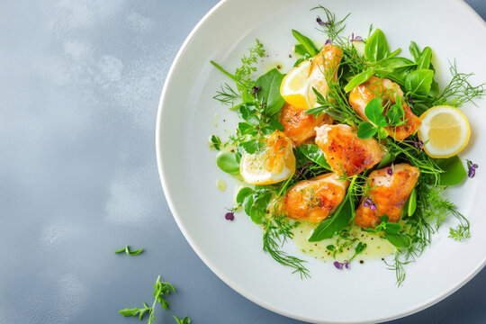 Gourmet frog legs with herbs and lemon slices