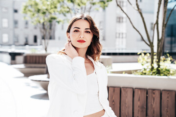 Young beautiful brunette woman wearing nice trendy white suit jacket. Sexy smiling model posing in...