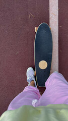 Skateboarder on city sidewalk, wearing sneakers and casual outfit