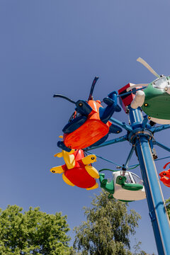 Colorful helicopter ride at amusement park under blue sky