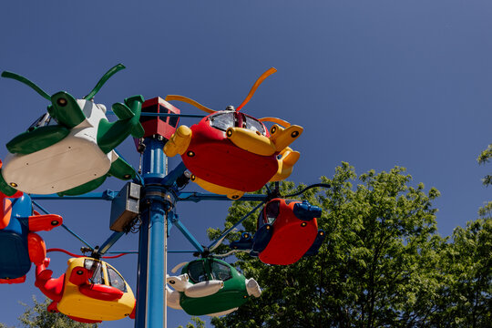 Colorful helicopter ride at amusement park under blue sky
