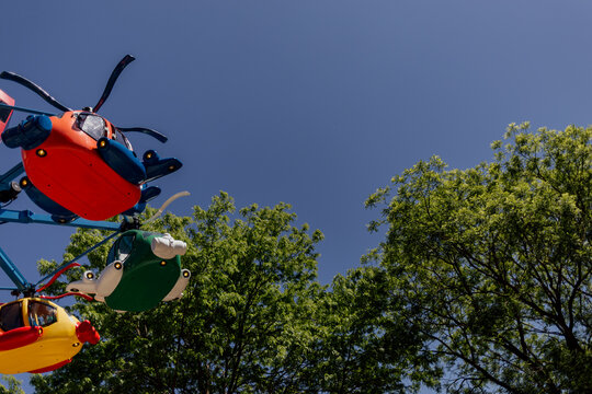Colorful helicopter ride at amusement park under blue sky