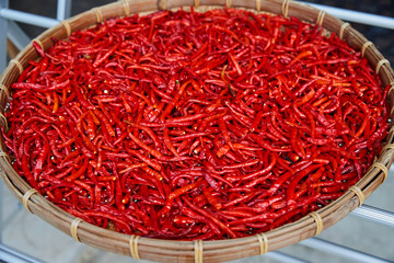Red chili peppers in sun drying in wicker basket