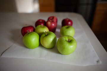 Fresh red and green apples sitting on counter in home kitchen