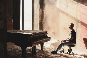Person sitting by a piano in a sunlit, dusty room