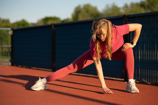 Woman Stretching Outdoors in Athletic Wear