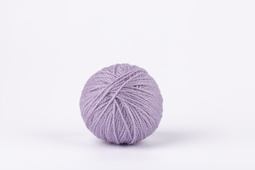 Lilac yarn ball on white background, minimalist style with soft tones and copy space. Concept of soft color design and creative lifestyle