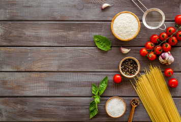Food ingredients for cooking Italian pasta with tomatoes and basil leaves, top view