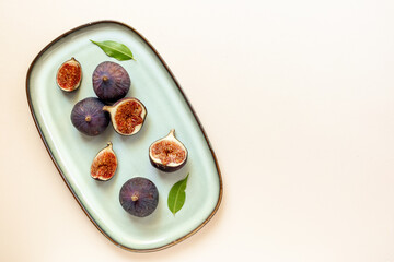 Fresh ripe figs on a plate top view on a stone background