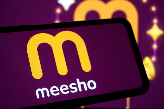 Meesho Logo Displayed on Smartphone with Branded Background