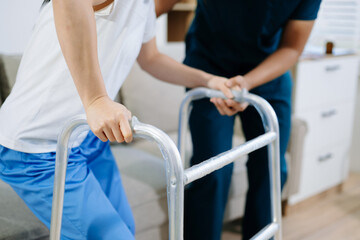 Closeup view of patient using walker during physical therapy with healthcare professional support, showing recovery, rehabilitation, and mobility training care.