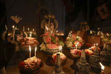 Spiritual offering with candle light during traditional ceremony on an altar. solemn, dark scene for worship, showing ancient belief and cultural festival at night